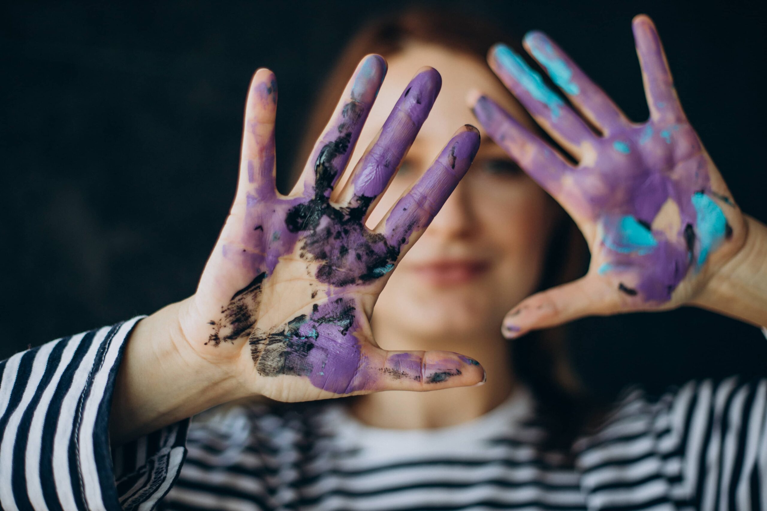 femme artiste avec peinture sur les mains violet bleu noir